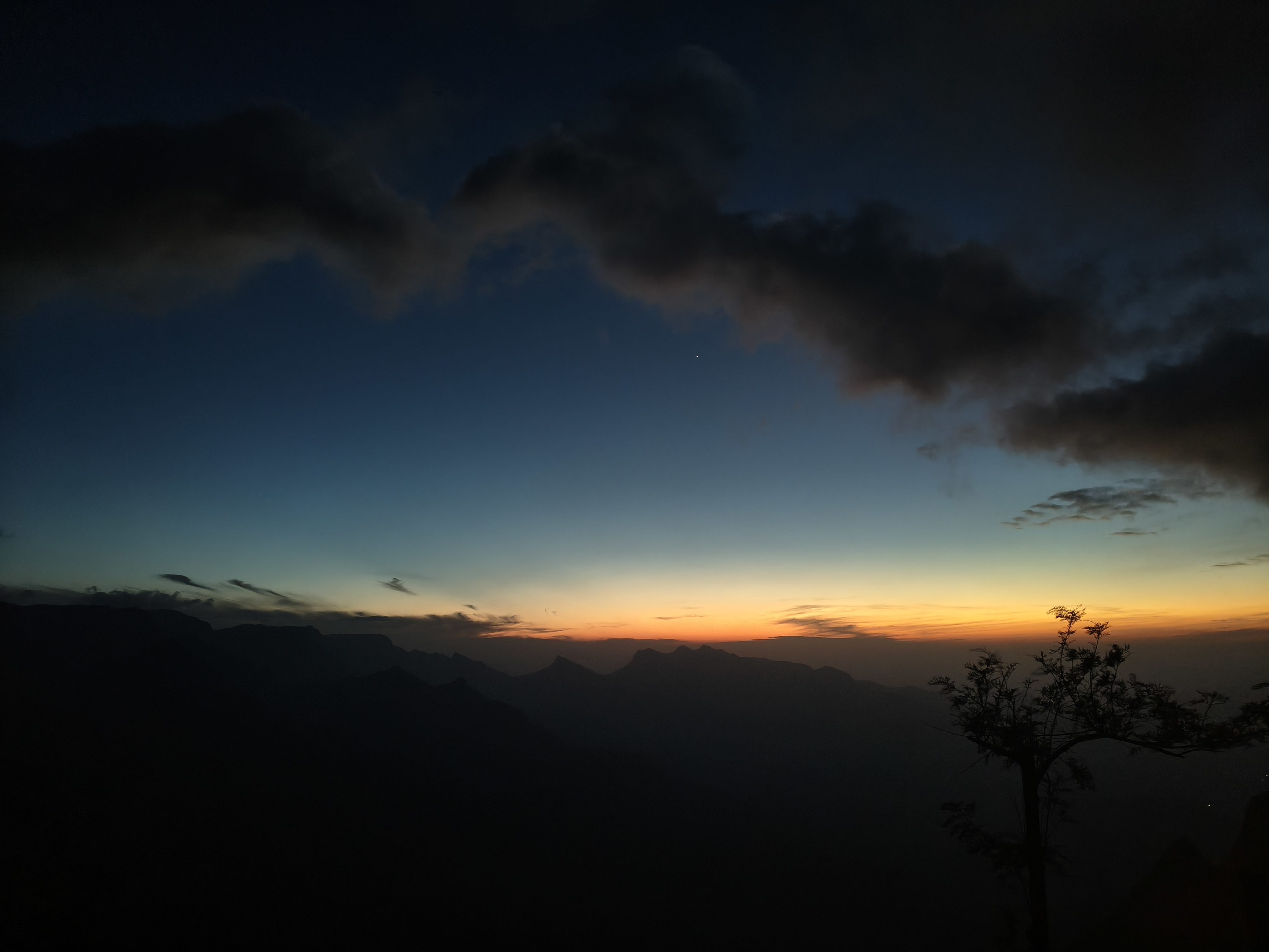 Kolukkumalai cloud valley view with lush green forest and bright blue sky